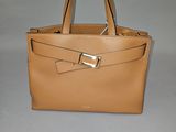 sac à main en cuir beige orné de boucles dorées sur fond gris