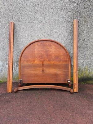 a bed with a wooden headboard and two wooden poles