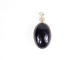 un pendentif en pierre noire muni d'une bélière en argent, sur fond blanc