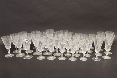 twelve wine glasses lined up in a row on a black surface