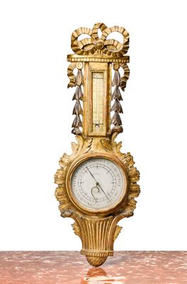 a gold clock sitting on top of a marble table