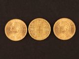 three different types of gold coins on a black background
