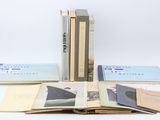 several books are stacked on top of each other on a white surface