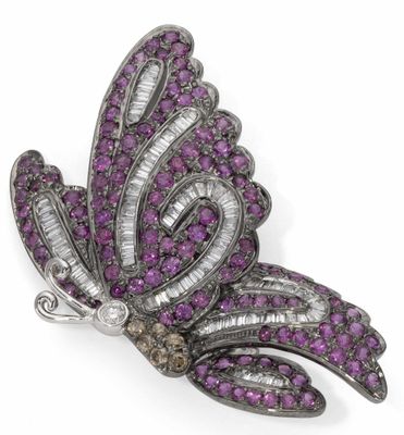 un gros plan sur une broche en forme de papillon violet et blanc