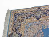 a blue rug with a gold border on a white background