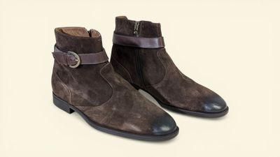 a pair of brown sued boots with a buckle on the side