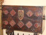 a wooden chest sitting next to a mirror on the wall
