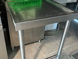 a stainless steel table with a green basket on top of it
