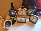 de nombreuses horloges différentes posées les unes à côté des autres sur une table