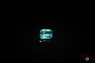 a green emerald in the dark with a black background