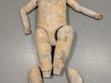 une image représentant une petite poupée se trouve sur une surface grise