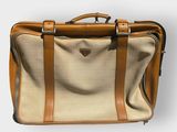 a tan suitcase with a tan handle on a white background