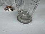 a glass vase with a bird on it sitting on a table
