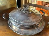 a silver plate with a bird on it sitting on a table