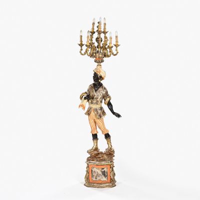 une figurine représentant un homme surmontée d'un lustre