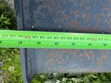 a green ruler that is on top of a trash can