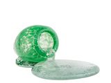 un objet en verre vert posé sur une assiette en verre