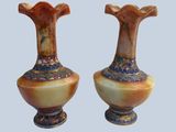 pair of vases sitting on top of each other on a blue surface