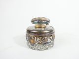 a small glass jar with a lid on a white surface
