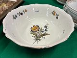 une table verte sur laquelle sont disposés des assiettes, des bols et des vases