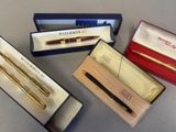 three pens and a pen in a box on a table