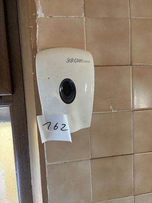 a paper towel dispenser attached to the wall of a bathroom