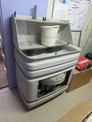 a sink with a bucket on top of it in a room
