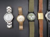 cinq modèles de montres différents sur un fond noir