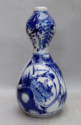 a blue and white vase with a woman on it