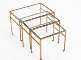three brass and glass nesting tables on a white background