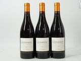 three bottles of wine sitting on top of a white table
