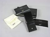 two black leather wallets and a white cloth are on a table