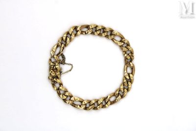 a close up of a gold chain bracelet on a white surface
