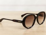 a close up of a pair of sunglasses on a wooden table