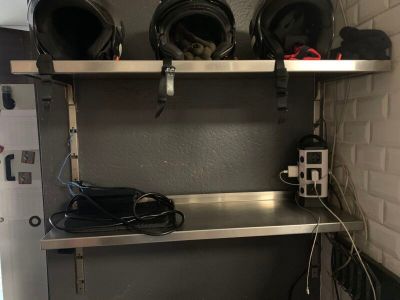 une étagère métallique sur laquelle sont posés des casques, dans une pièce
