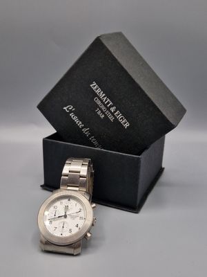 une image représentant une montre dans un coffret, avec un autre coffret en arrière-plan