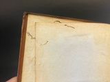 a person holding an old book in their hand