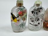 three glass vases with birds and flowers painted on them