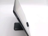 a tablet computer sitting on a stand on a white surface