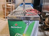 distributeur de bière Heineken dans une cuisine, à côté d'un réfrigérateur