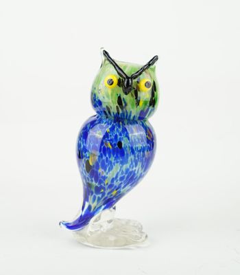 blue and green owl figurine sitting on a clear base