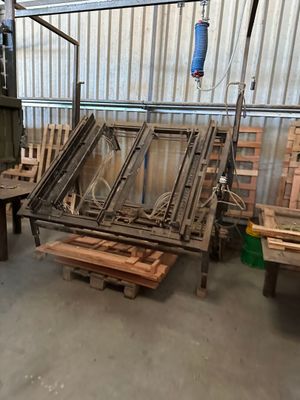 many wooden chairs and a table in a warehouse