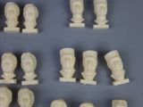 a lot of white marble heads on display on a table