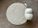 a white elephant statue on a table with a brown background