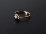 un gros plan d'une bague en or sertie d'un diamant sur un fond noir
