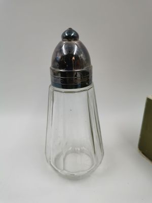 une image représentant un ensemble de sel et de poivre en verre muni d'un couvercle en métal