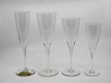 trois verres à vin vides posés l'un à côté de l'autre sur une surface blanche