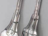 two forks that are sitting next to each other on a table