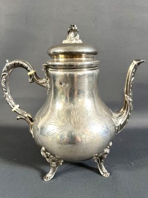 une théière ancienne en argent avec couvercle, posée sur un socle