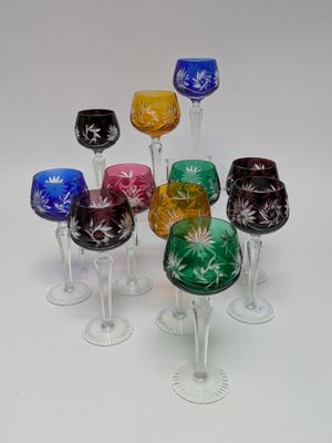 six wine glasses sitting in a row on a white surface
